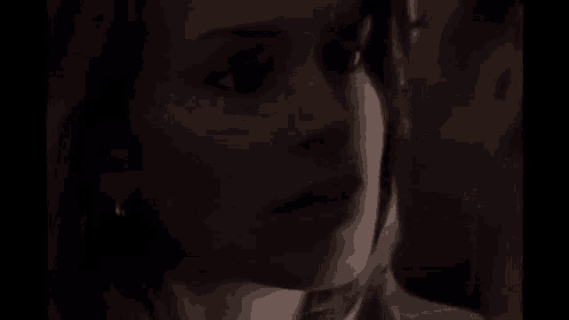 a man and a woman are kissing in a dark room in a black and white photo .