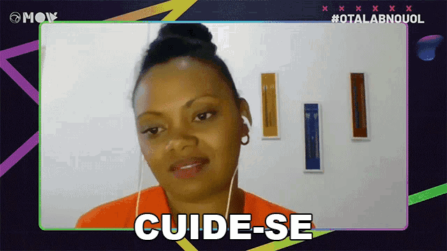 a woman wearing ear buds says " cuide-se " in a video