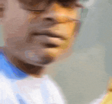 a blurry picture of a man 's face with a blue shirt on