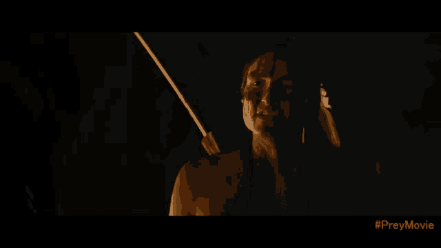 a screen shot of a prey movie with a woman holding a stick in her hand