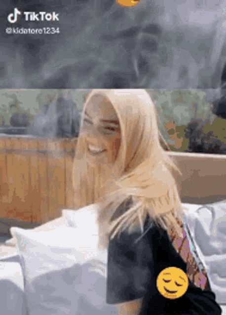 a woman wearing a hijab is smiling and smoking a cigarette