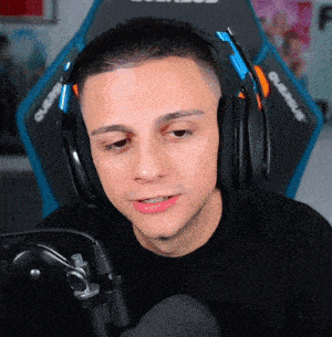 a man wearing headphones is sitting in front of a microphone and a chair that says olympus on it