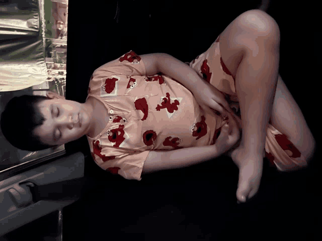 a young boy in elmo pajamas is sleeping