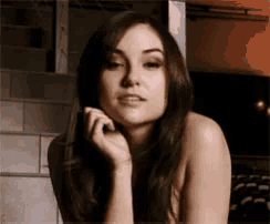 a woman without a shirt is looking at the camera