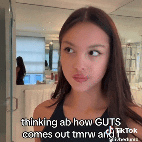 a woman in a bathroom with a caption that says " thinking ab how guts comes out tmrw and tiktok "