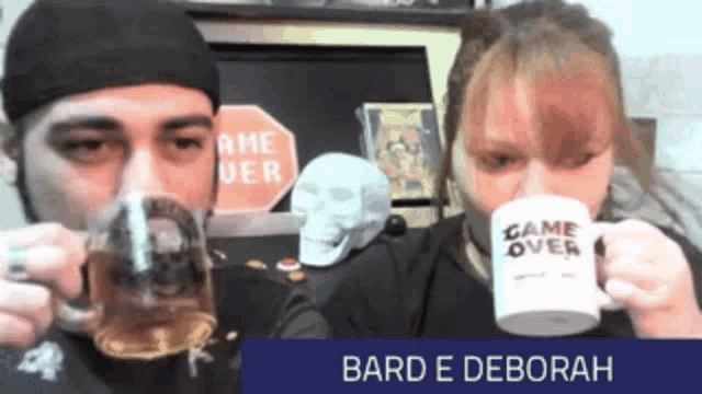a man and a woman drink from mugs that say game over