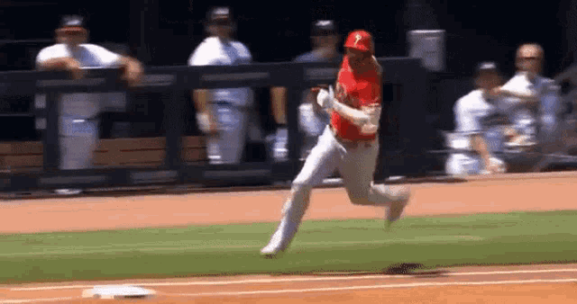 a baseball player is running to first base on a field .
