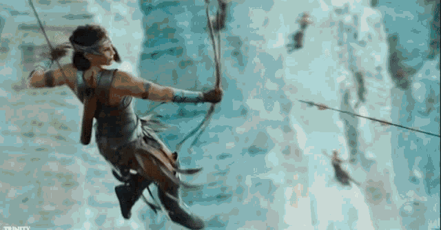 a woman is flying through the air with a bow and arrow in her hand .