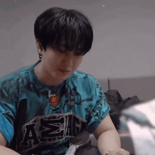 a man wearing a tie dye shirt with the letter a on the front