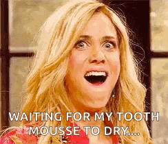 a woman is waiting for her tooth to mousse to dry .