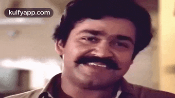 a close up of a man with a mustache smiling .