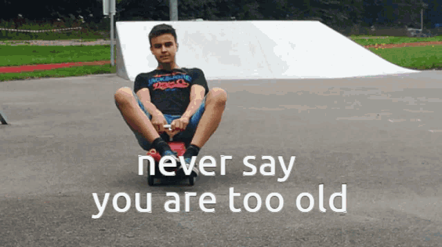 a boy sits on a skateboard with the words never say you are too old