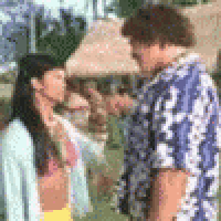 a man and a woman are standing next to each other in a park .