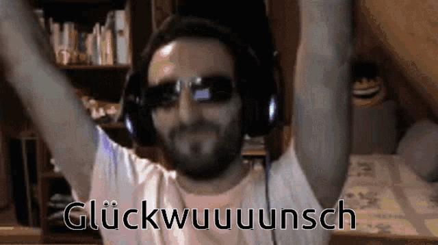 a man wearing headphones and sunglasses says glückwuuuunsch with his arms in the air