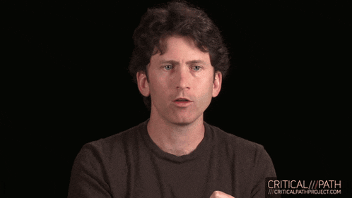 a man in a black shirt is talking in front of a black background that says critical / path