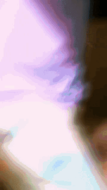 a blurry picture of a person 's face with a purple and blue background
