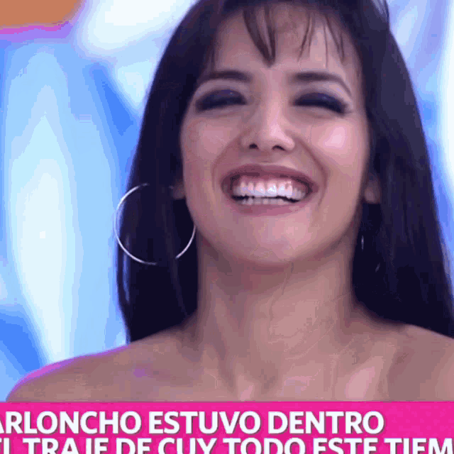 a woman with hoop earrings is smiling in front of a sign that says ' arloncho estuvo dentro '