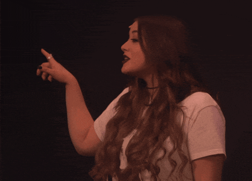 a woman with long red hair is wearing a white t-shirt that says " i love you "