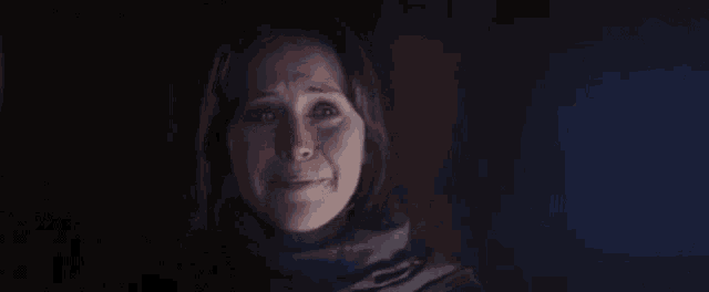 a woman is crying in a dark room .