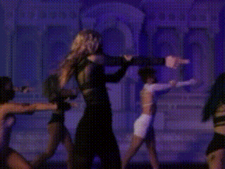 a woman in a black dress is dancing in front of a cemetery .