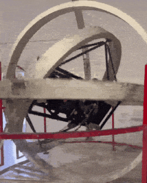 a gray and white circular object with a red border