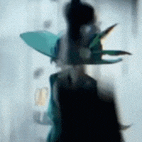 a blurry picture of a person wearing a green hat with wings