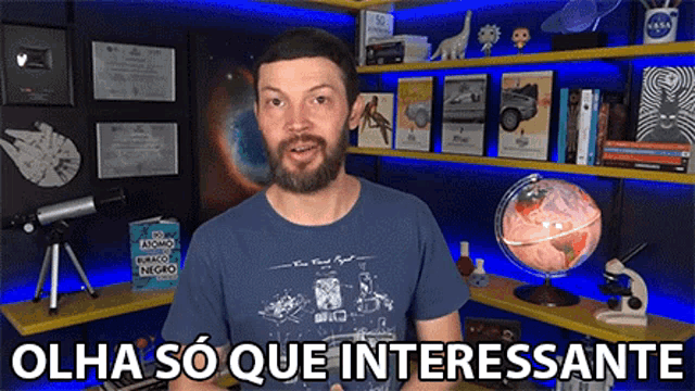 a man with a beard is standing in front of a bookshelf with the words olha so que interessante written on the bottom