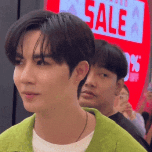 a man standing in front of a sign that says sale
