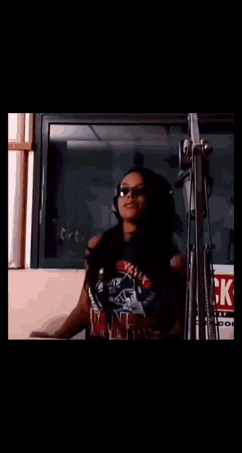 a woman wearing sunglasses and a shirt that says ' aaliyah ' on it