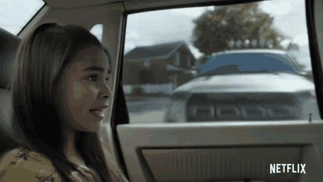 a girl sitting in a car with a netflix logo on the side