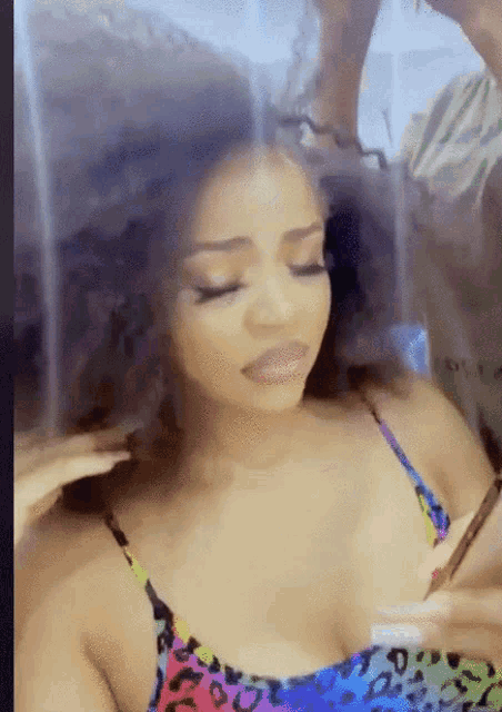 a woman in a leopard print top is getting her hair done by a man