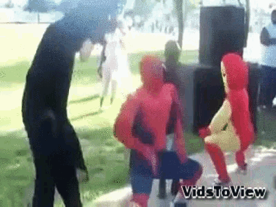 a group of people in spiderman costumes are dancing on a sidewalk ..