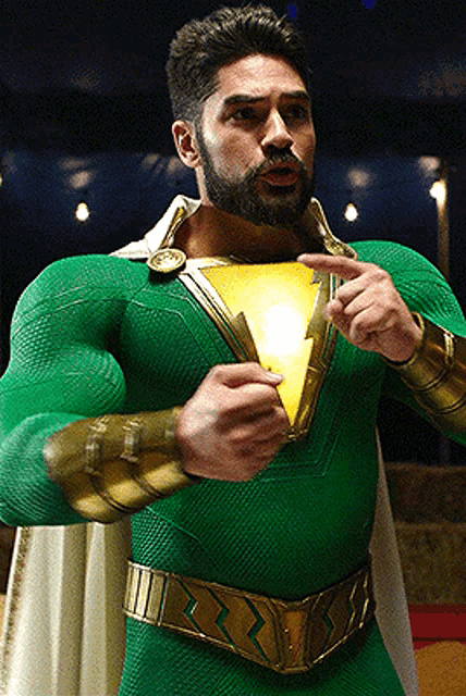 a man in a green and gold superhero costume holds a light