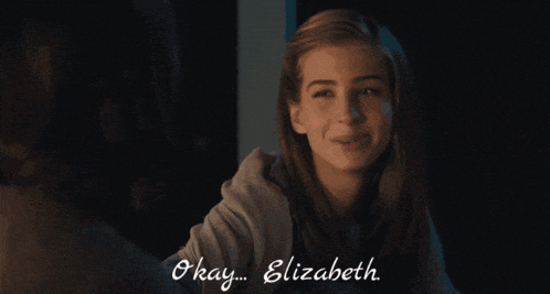 a girl winks and says okay elizabeth in front of a mirror