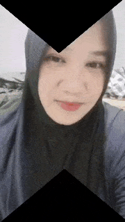 a woman wearing a hijab is taking a selfie with a camera .