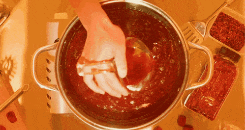 a person is pouring liquid into a pot with a ladle