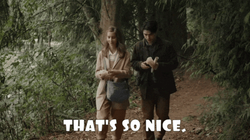 a man and a woman are walking in the woods with the words that 's so nice