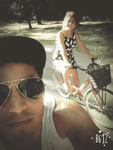 a woman riding a bike next to a man wearing sunglasses and a hat