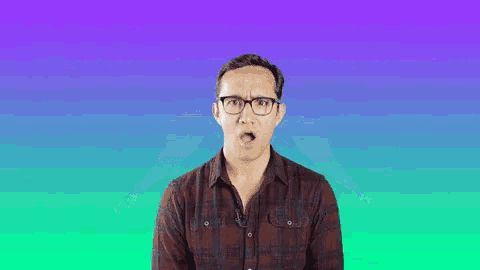 a man wearing glasses and a plaid shirt looks surprised