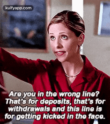 a woman in a red shirt is talking to another woman in a room .
