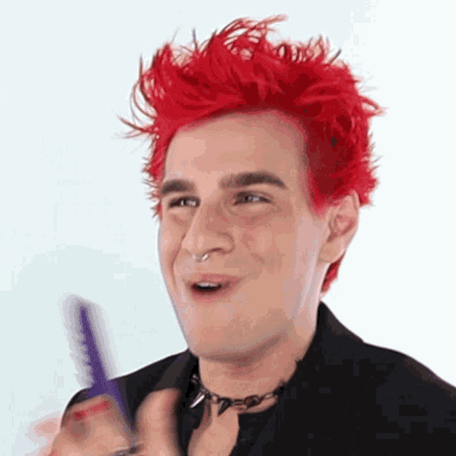 a man with bright red hair is holding a purple comb .
