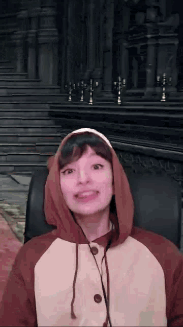 a woman wearing a bear costume is sitting in a chair and smiling .
