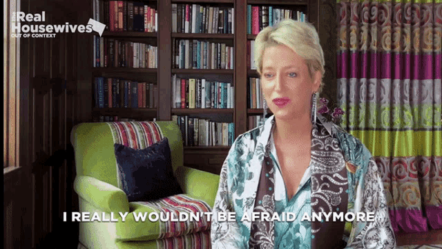 a woman is sitting in front of a bookshelf and says i really wouldn 't be afraid anymore