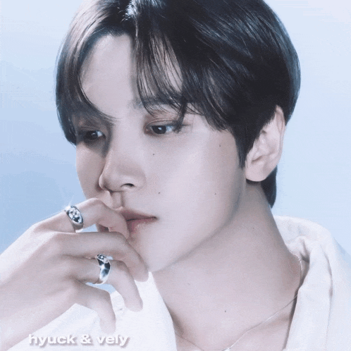 a close up of a person 's face with the words hyuck & vely written below it