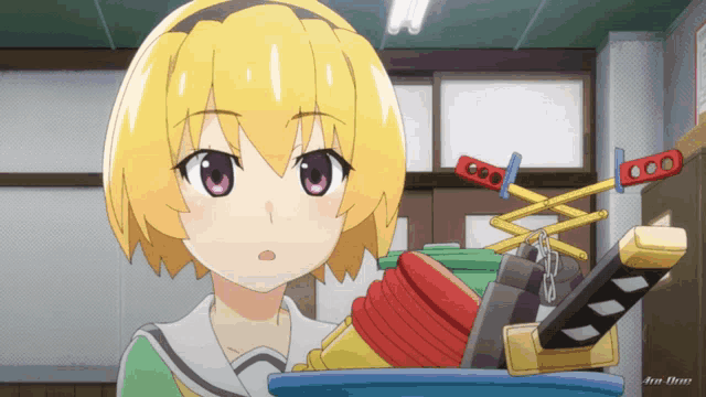 a yellow haired anime girl is standing next to a bucket of toys