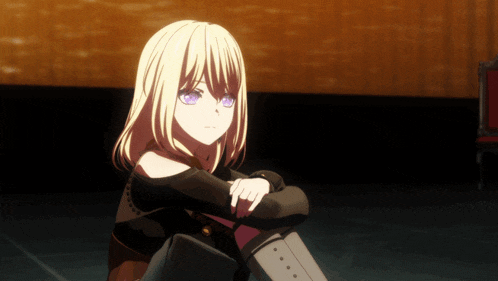 a girl with blonde hair and blue eyes sits on the floor