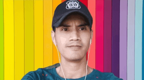 a man wearing a hat and ear buds is taking a selfie in front of a colorful background .
