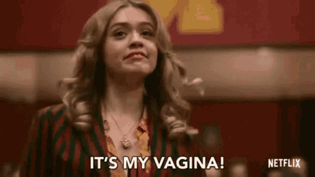 a woman is standing in front of a red wall and says `` it 's my vagina ! ''