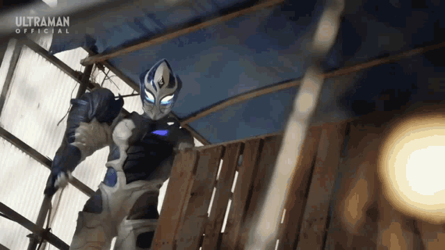 a man in an ultraman costume is standing in front of a wooden fence