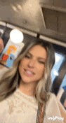 a woman is taking a selfie on a bus while smiling .